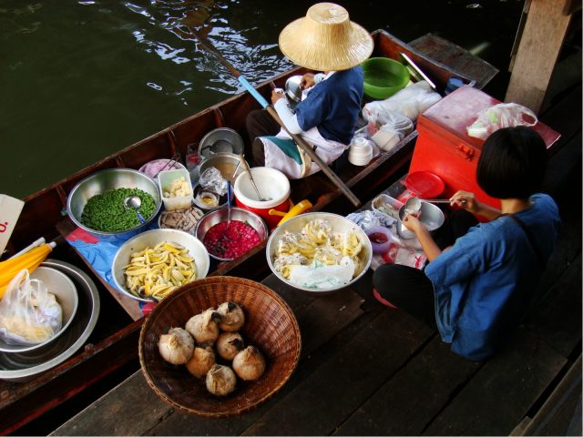 Women cooking food at a floating market in Bangkok